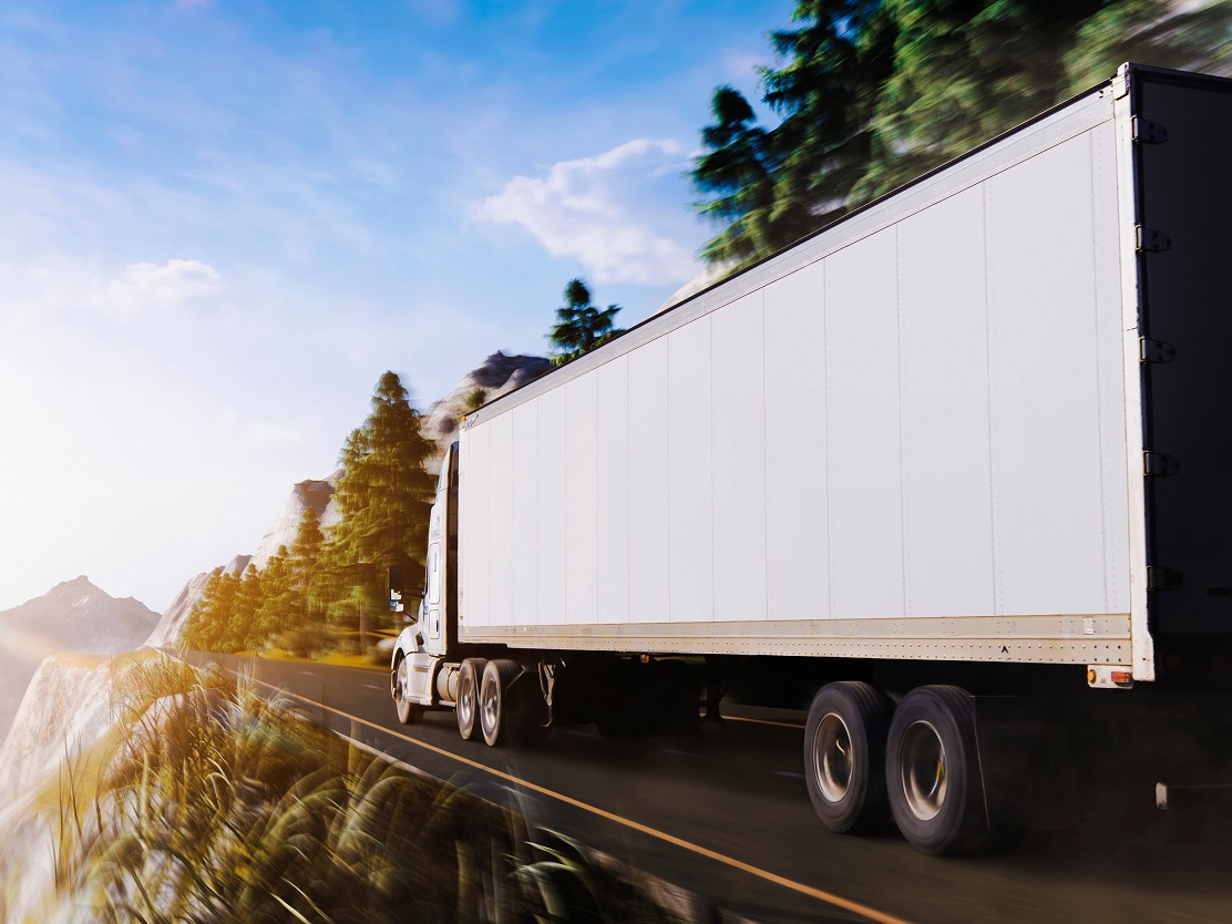 Truck driving out mountain towards the sun