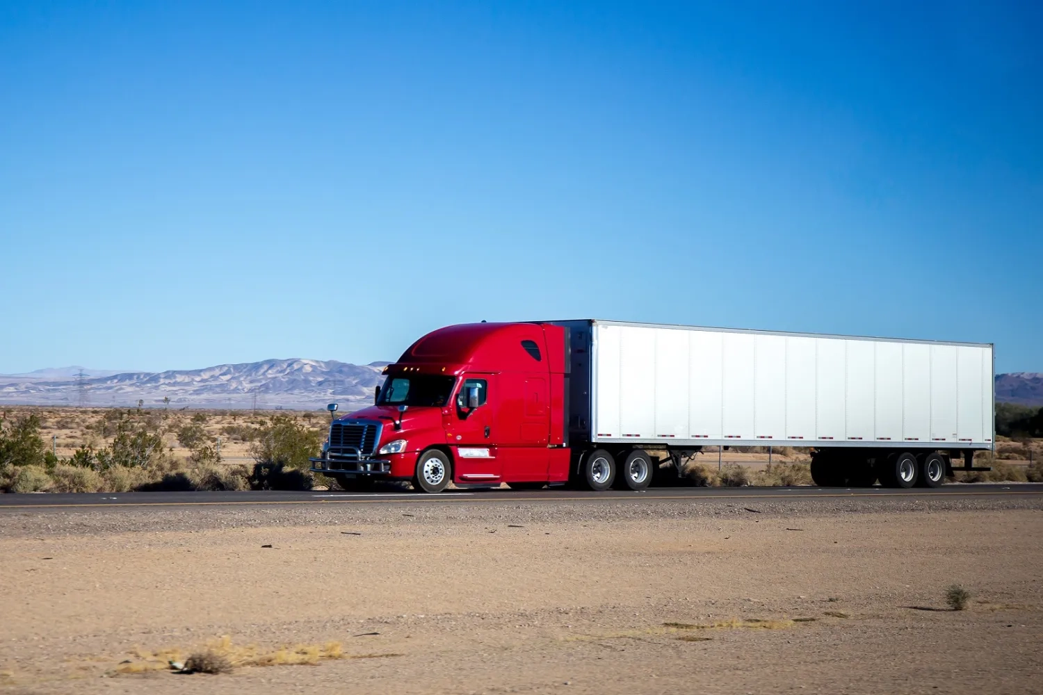 Red truck driving in desert